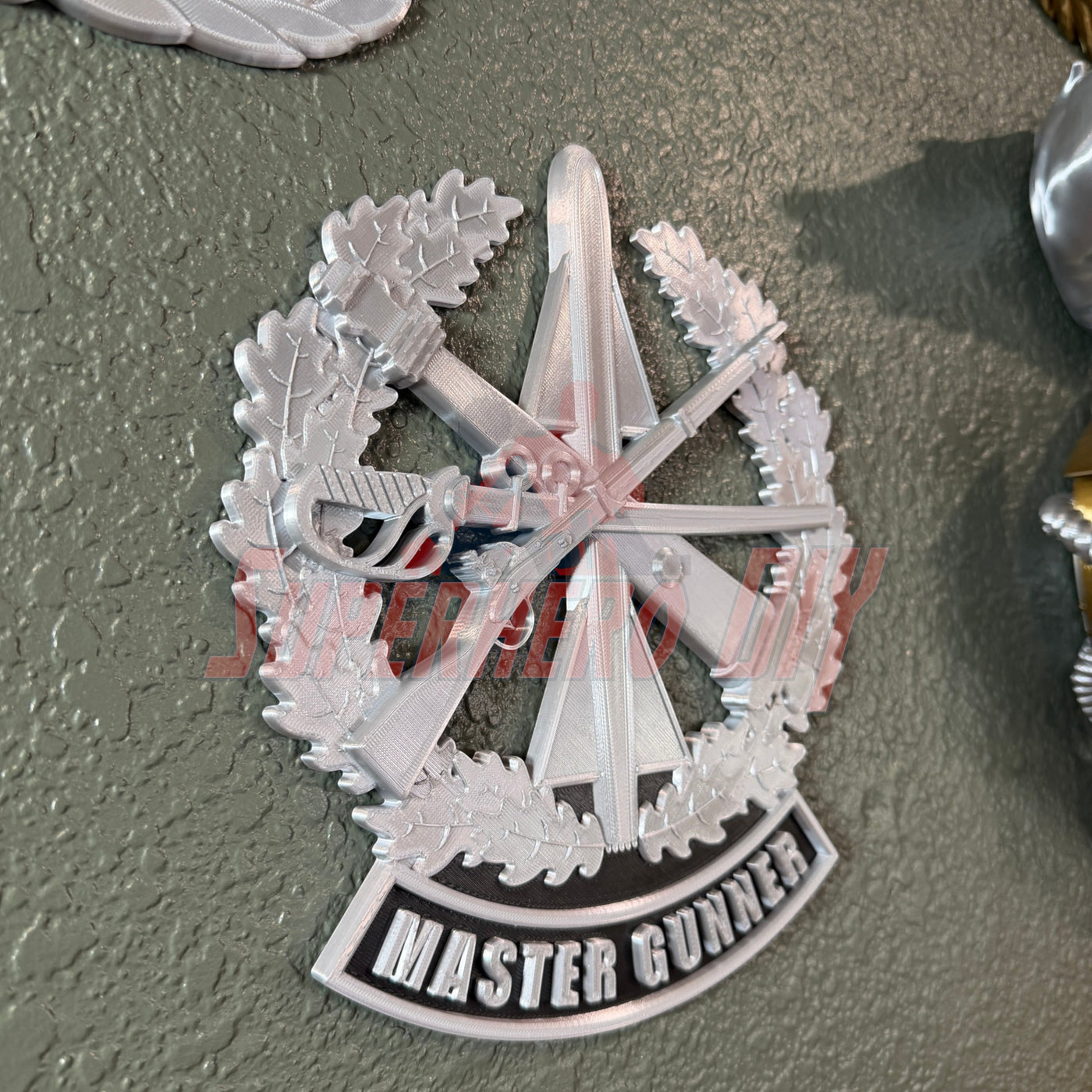 Master Gunner Badge display insignia mounted on a wall as a 3D display piece.
