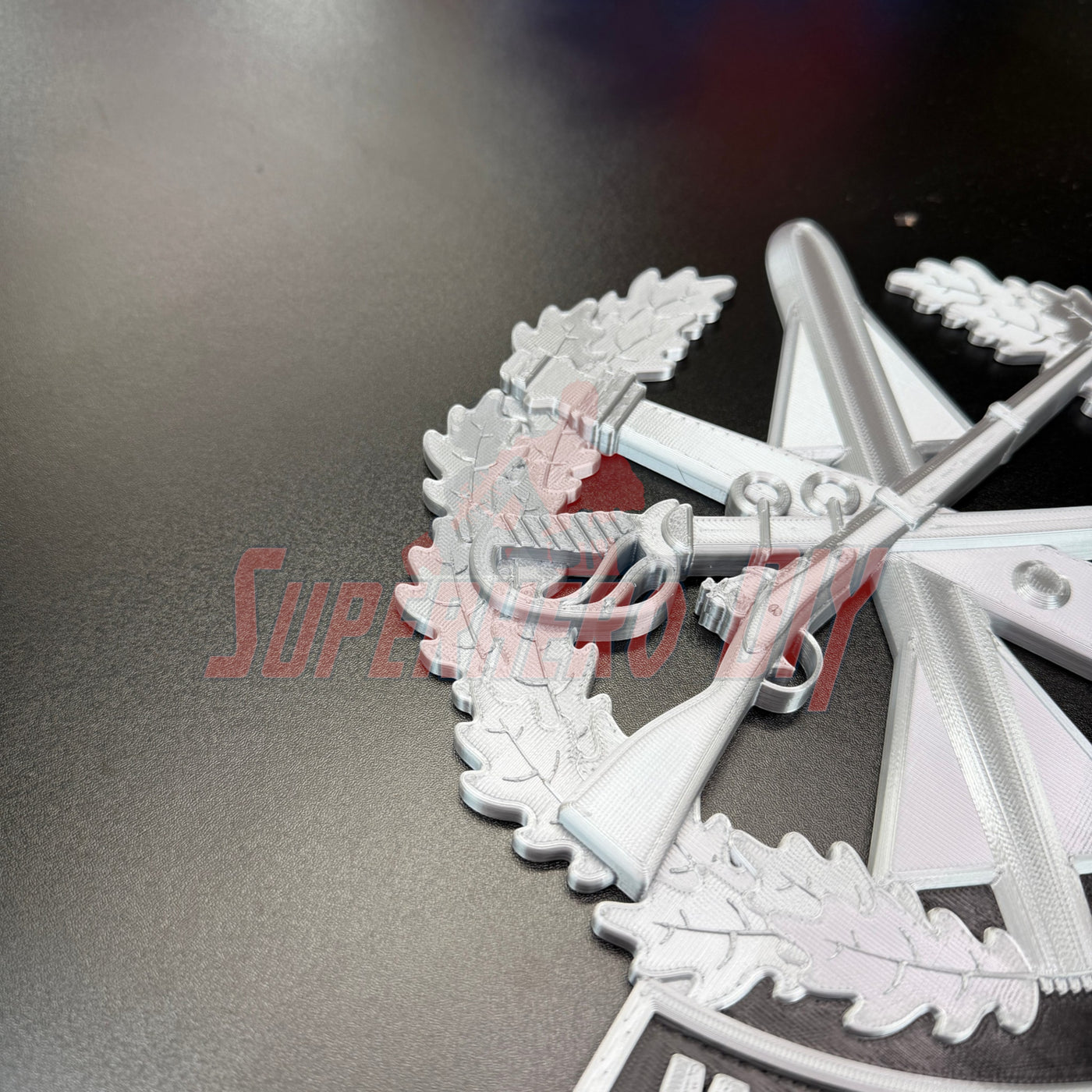 Close-up view of Master Gunner Badge display insignia featuring detailed design on a black background.