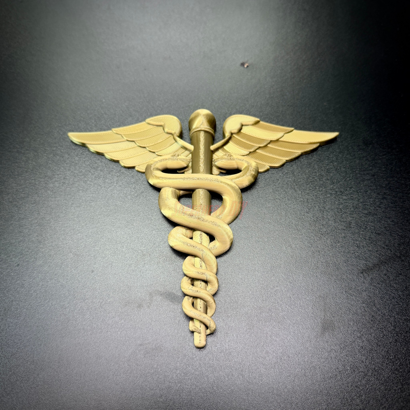 Army Medical Corps caduceus wall display, gold insignia with winged staff and twin serpents.