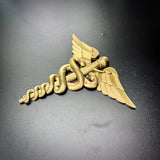 army medical corps caduceus wall display in gold color with wings and serpents on a dark surface