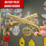 Army military police insignia displayed with golden crossed pistols on a wall of military patches.