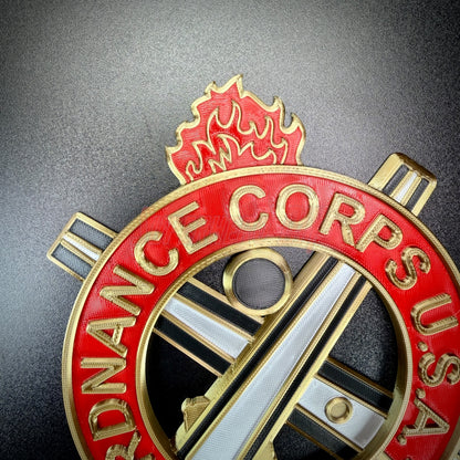 Ordnance regimental crest featuring flame emblem and crossed tools, representing the Ordnance Corps.