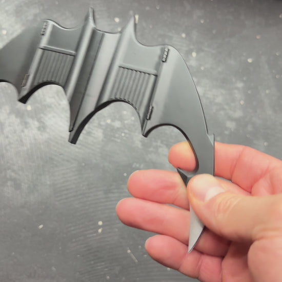 NECA BATMAN 1989 Folding Magnetic Batarang (LOOSE) held in hand, showcasing its sleek design and details.