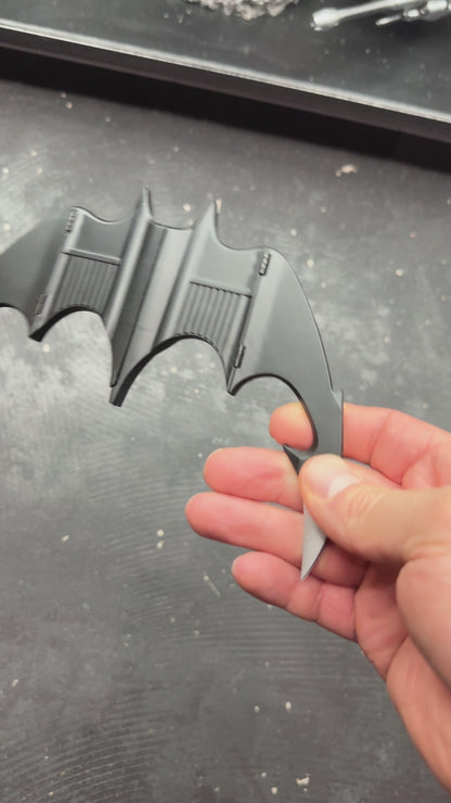 NECA BATMAN 1989 Folding Magnetic Batarang (LOOSE) held in hand, showcasing its sleek design and details.