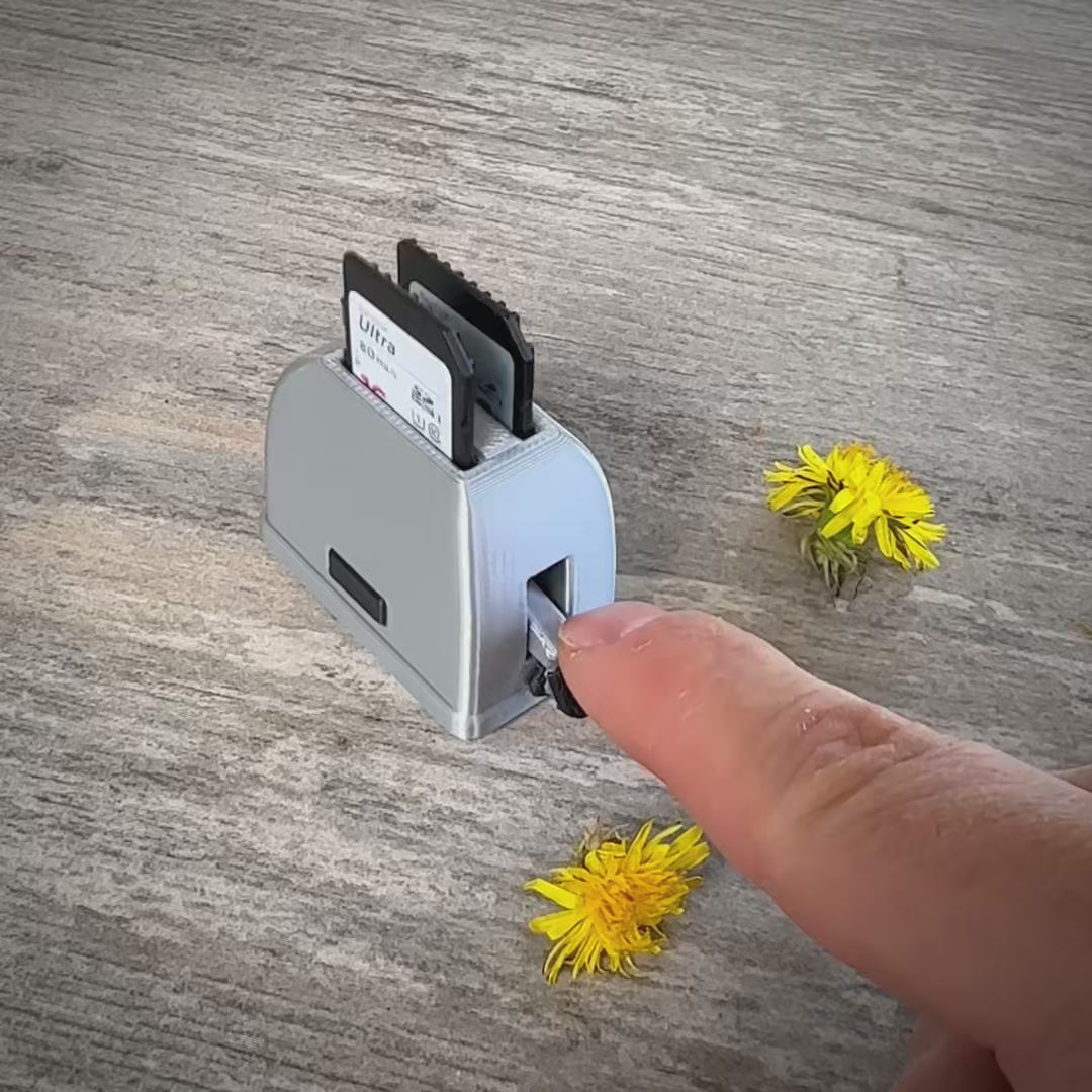 Mini toaster-shaped SD card holder that stores 2 memory cards and doubles as a fun desktop fidget
