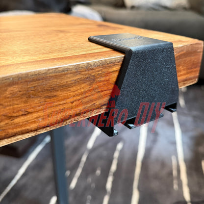 Under-desk PS5 controller mount attached to a wooden table edge for efficient storage.