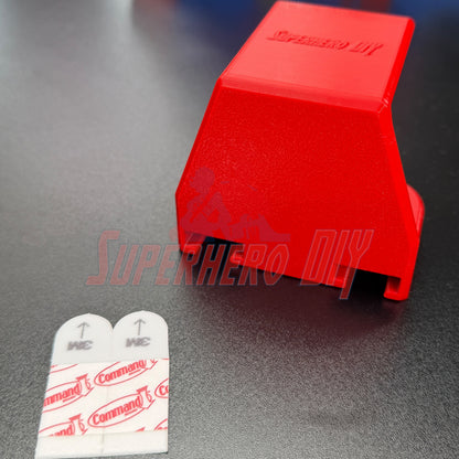 Under-desk PS5 controller mount in red with Command adhesive strips for easy installation.