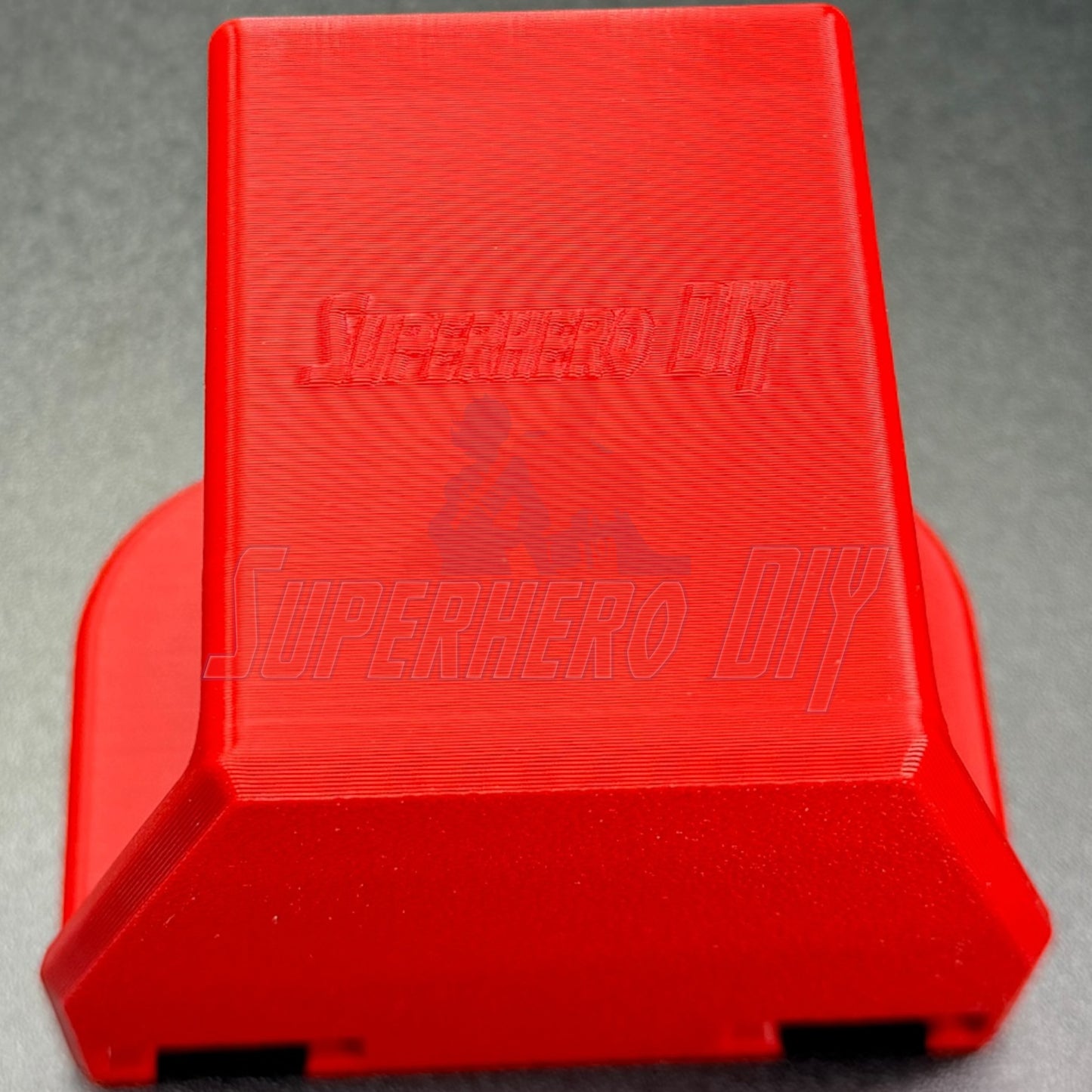 Under-desk PS5 controller mount in vibrant red, designed for charging while stored, no drilling required.