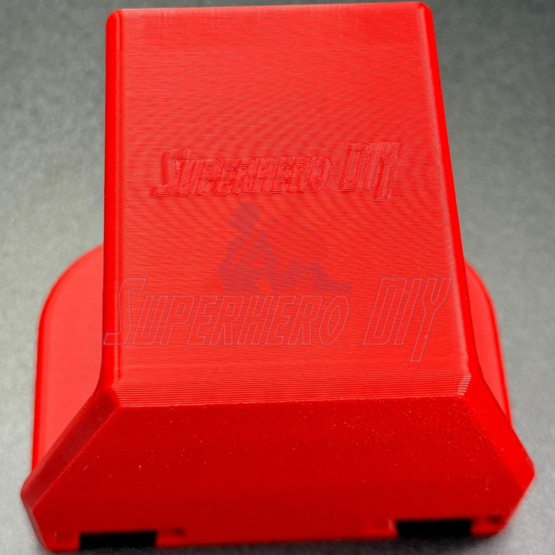 Under-desk PS5 controller mount in vibrant red, designed for charging while stored, no drilling required.