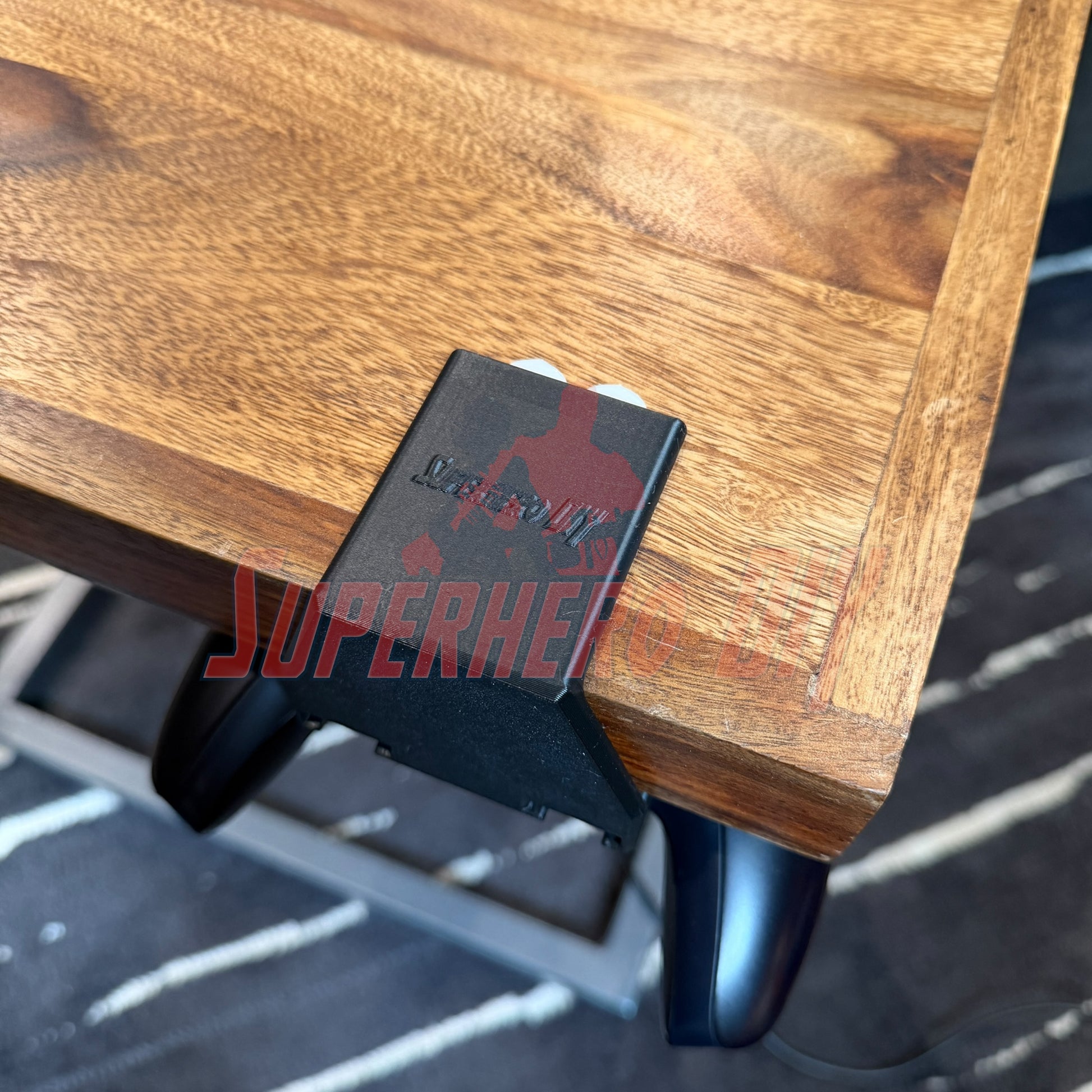 Under-desk PS5 controller mount attached to a wooden desk, securely holding the controller underneath.