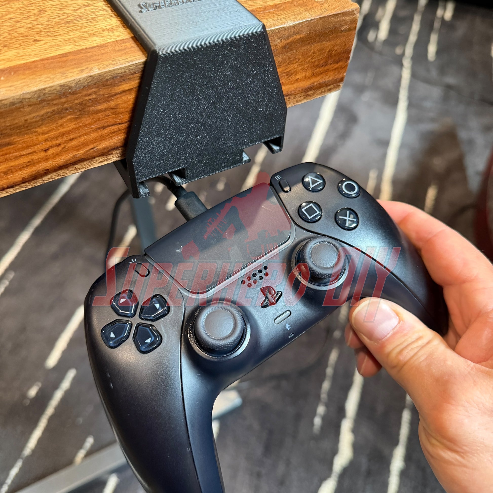 Under-desk PS5 controller mount holding a PS5 controller for easy charging and storage without drilling.