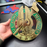 Hand holding an Army Recruiter Badge insignia with eagle and stars, showcasing the U.S. Army Recruiter emblem.