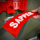 3D Sapper Tab display piece in red with white lettering, showcasing the achievement of combat engineers.