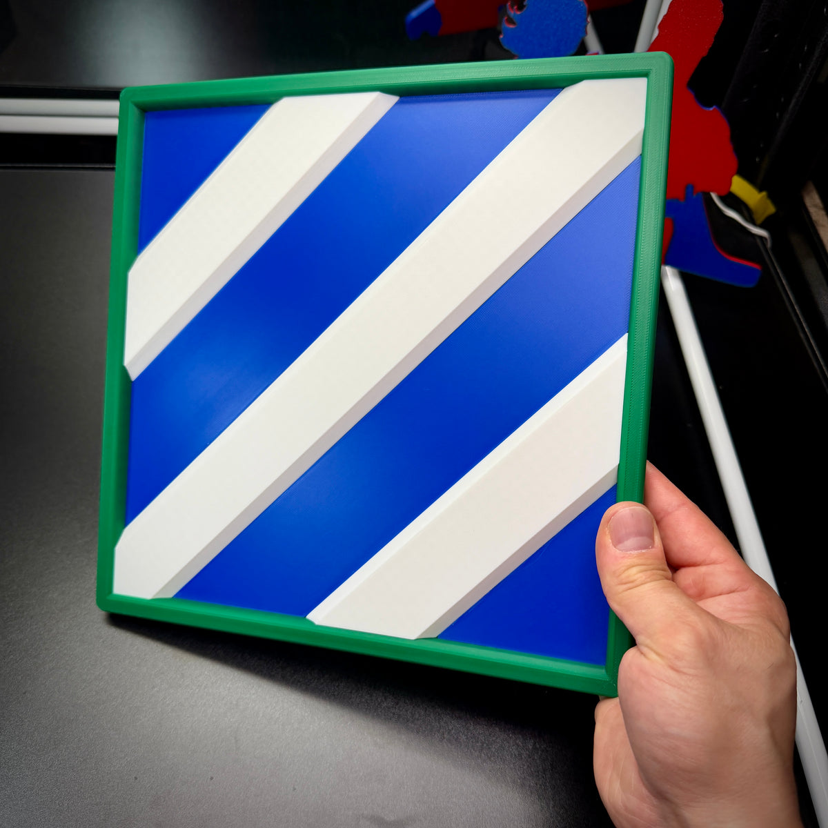 3rd Infantry Division display insignia in bold blue and white, held by a hand, available in multiple sizes.