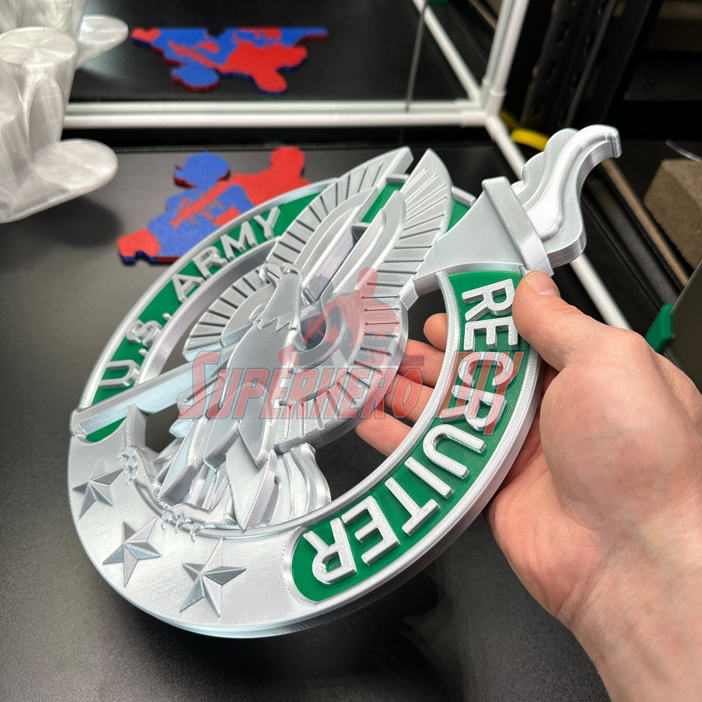 Hand holding Army Recruiter Badge Insignia with eagle and torch detail.