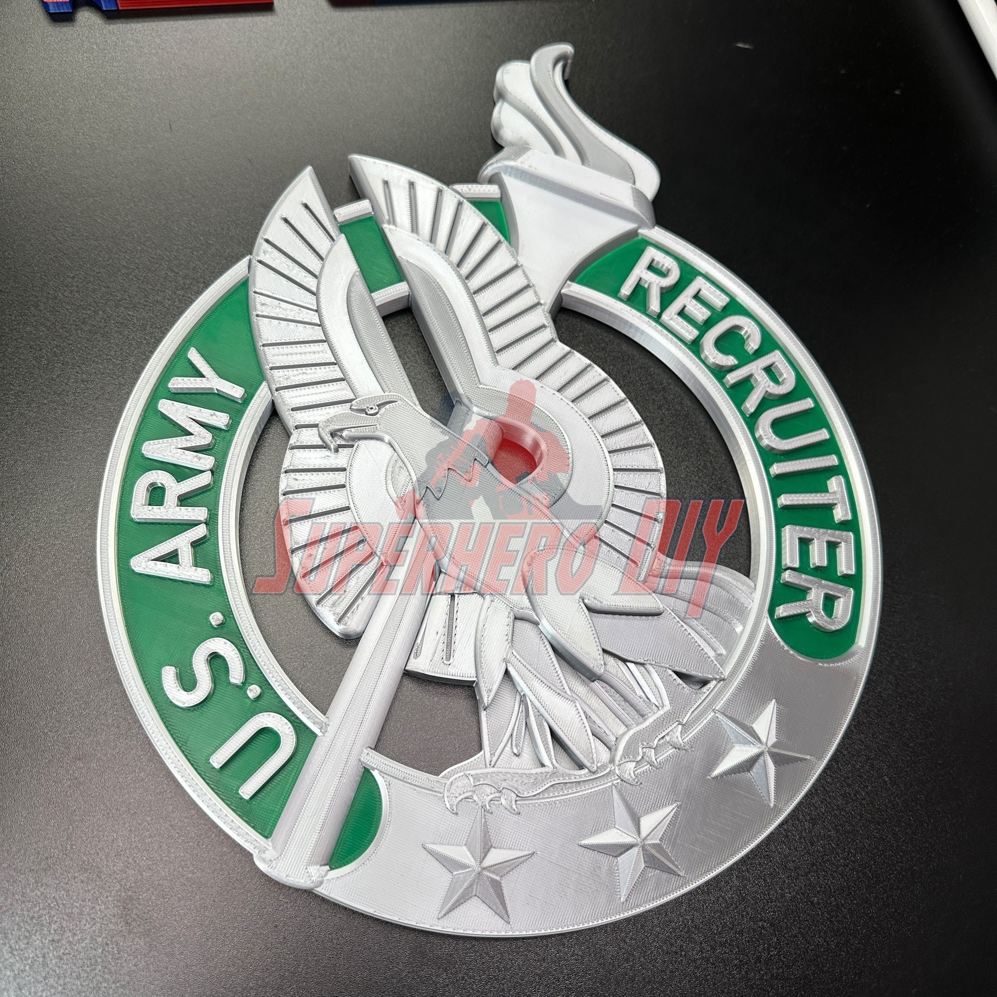 Army recruiter badge display with eagle, torch, and stars, metallic design for wall decor.