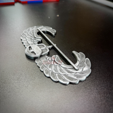 Subdued Air Assault Badge detailed view on a black surface showcasing wings and insignia.