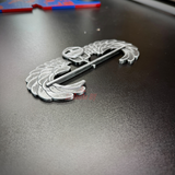 Subdued air assault badge display piece on a black surface for military showcase.