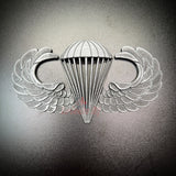 Subdued airborne jump wings badge featuring iconic parachute and wings design.