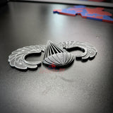 Subdued airborne jump wings badge with wings detail on a dark background, ideal for veterans and collectors.