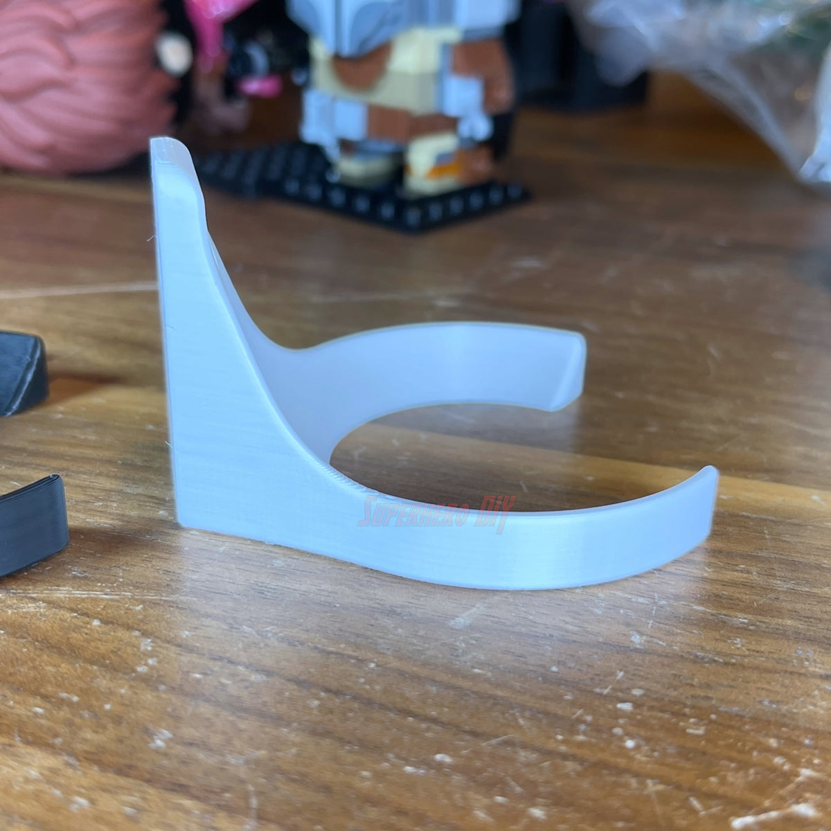 White baseball holder wall mount standing on a table, side profile