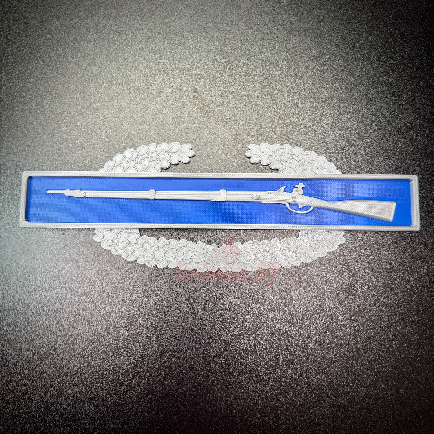 Combat Infantryman Badge (CIB) replica displayed on a blue background with a rifle design.