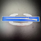 Combat Infantryman Badge (CIB) replica displayed on a blue background with a rifle design.