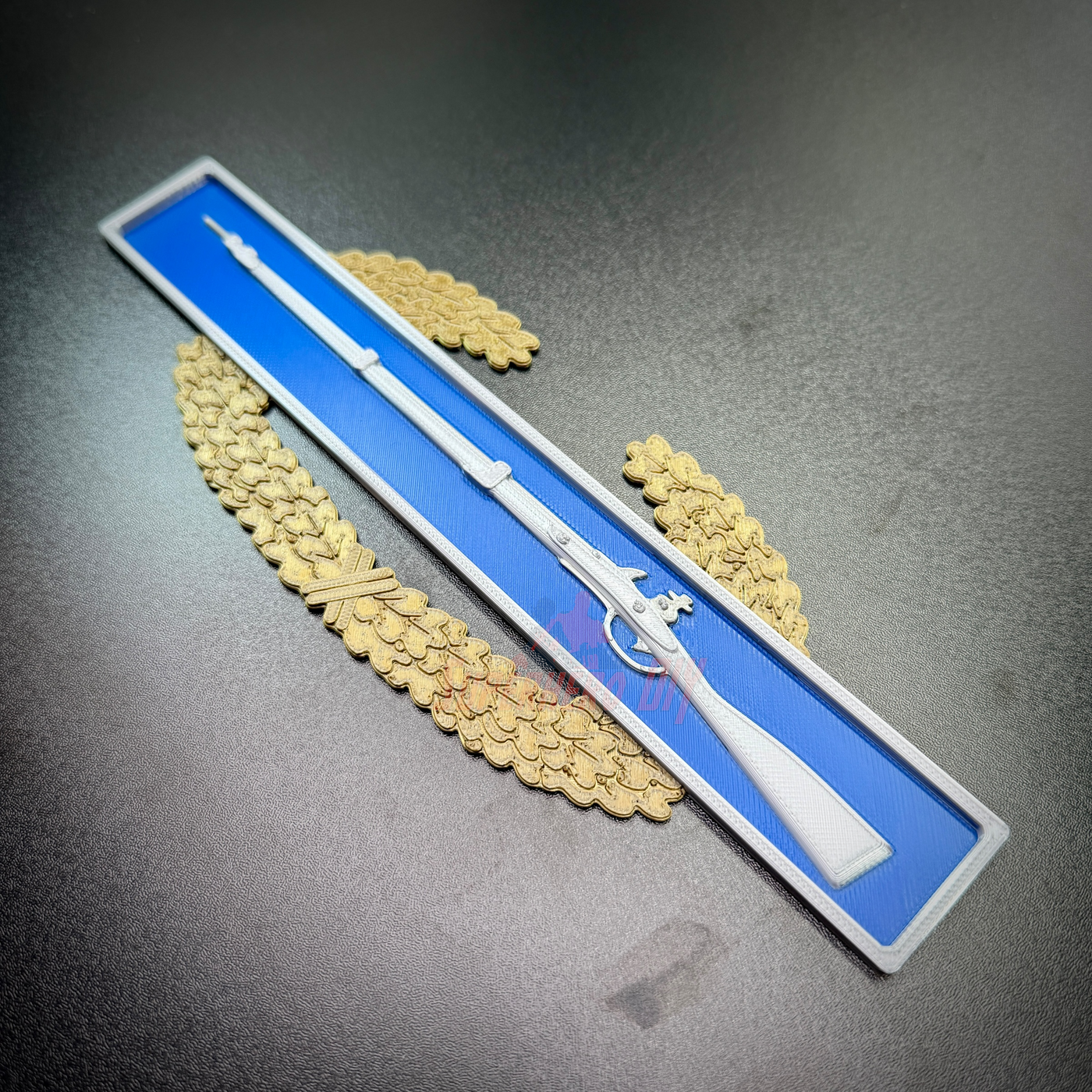 Master Combat Infantryman Badge (MCIB) replica on a blue background with golden wreath embellishments.