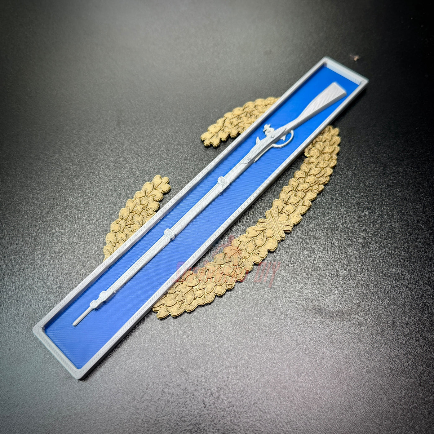 Master Combat Infantryman Badge (EIB) replica displayed on a blue background with a decorative border.