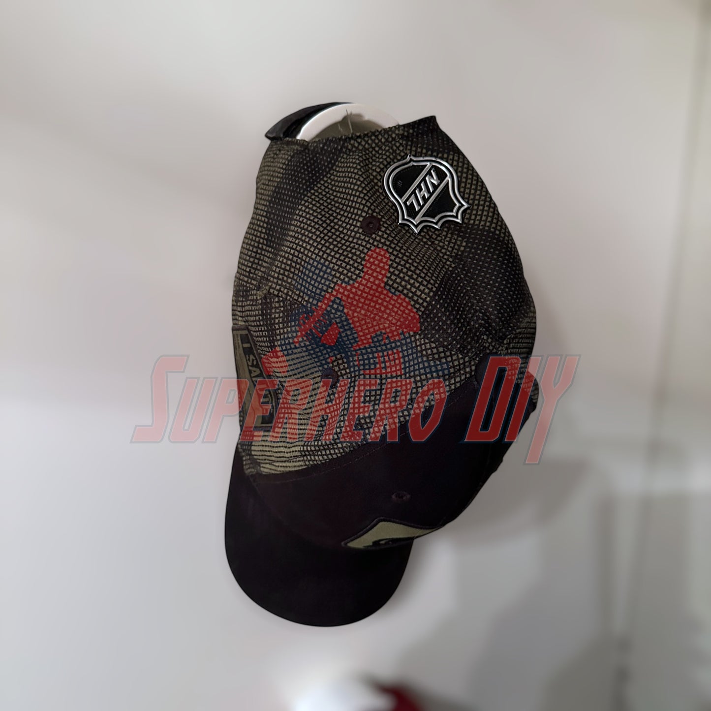 Black hat displayed on wall mount, featuring superhero design, highlighting effective hat display wall mount use
