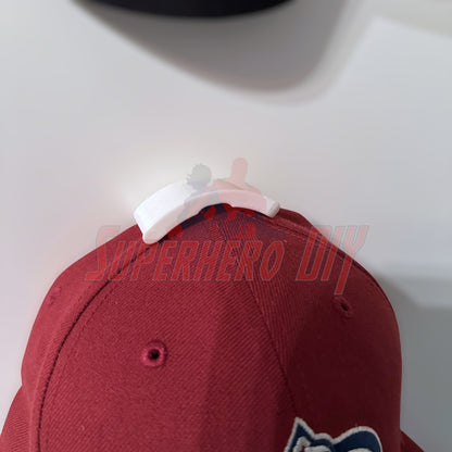Hat display wall mount showcasing a maroon cap, ideal for organizing and displaying hats without wall damage.