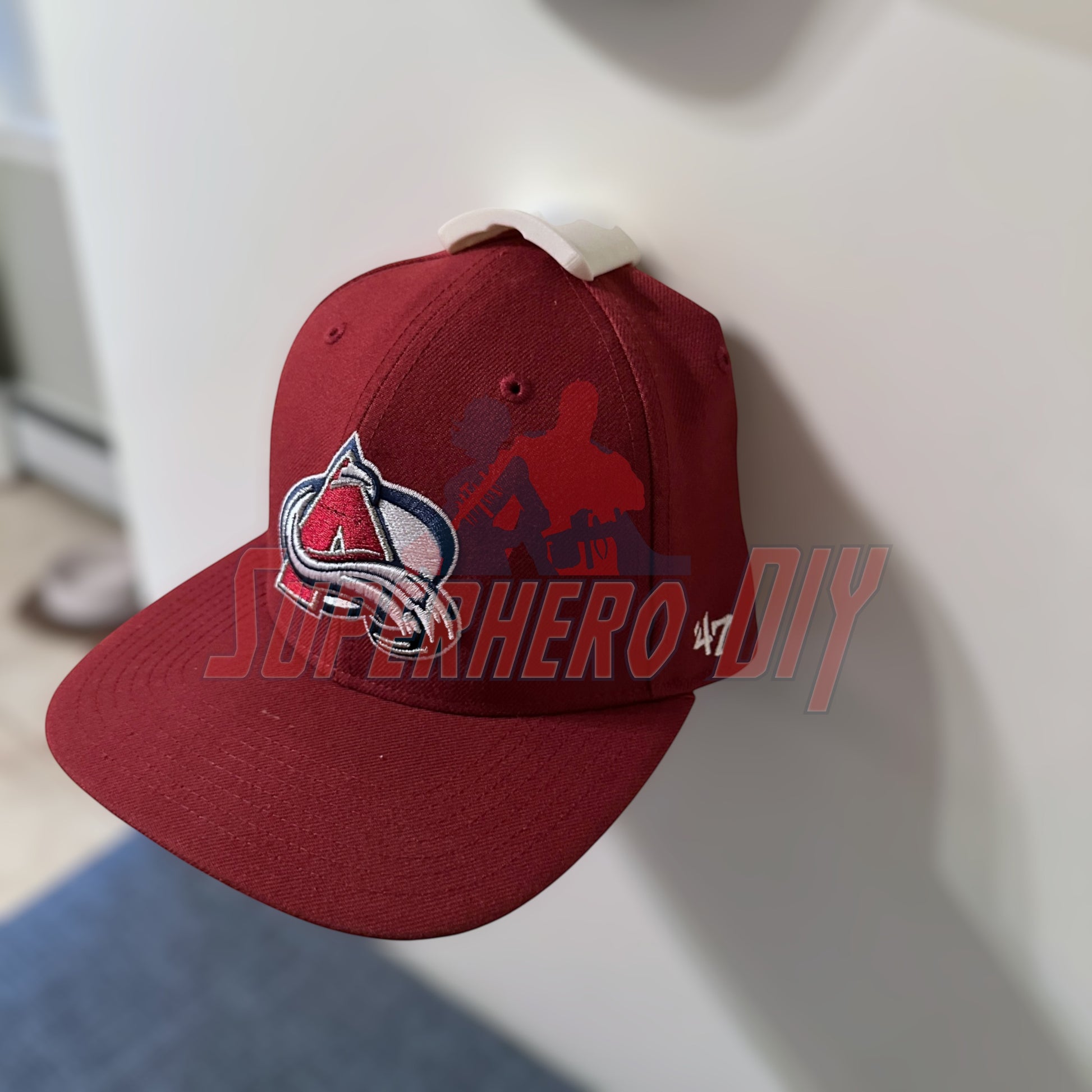 Red cap on hat display wall mount using wall hooks for easy organization