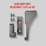 Skadis-mount Elbow Pad hook with mount, T-clips, and tool on a gray background