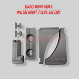 Skadis-mount hooks with mount, T-clips, and tool on a gray background