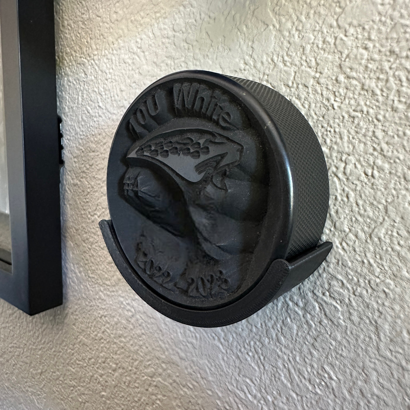 Hockey puck holder wall mount featuring a detailed design, ideal for displaying championship pucks.