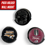 Three hockey pucks displayed on a wall mount, showcasing different designs with a puck holder wall mount design.