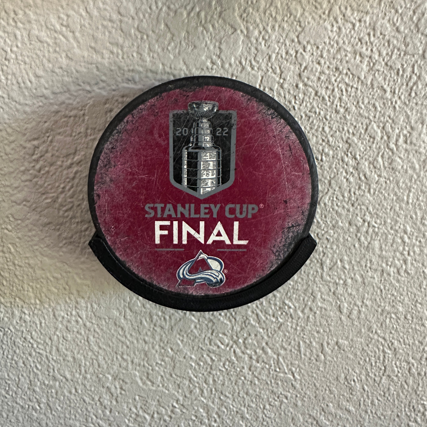 Stanley Cup Final hockey puck mounted on a wall, commemorating the 2022 championship.