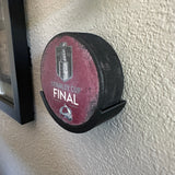 Hockey puck holder displaying a Stanley Cup Final 2022 puck on a wall, perfect for hockey enthusiasts.