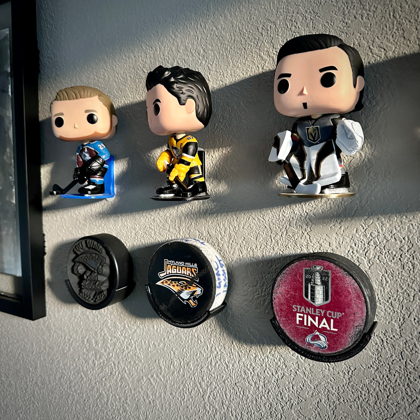 Hockey puck holder wall mount displaying collectibles and Stanley Cup Final hockey puck.