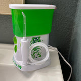 Lid for Waterpik Traveler Water Flosser WP-300 in green and white on a bathroom counter with water tube.