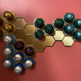 Honeycomb wall mount displaying original Nespresso coffee pod organizer holding colorful capsules on a wall.