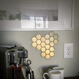 Honeycomb wall mount for original Nespresso coffee pod organizer, showcasing hexagonal design with coffee machine and cups.