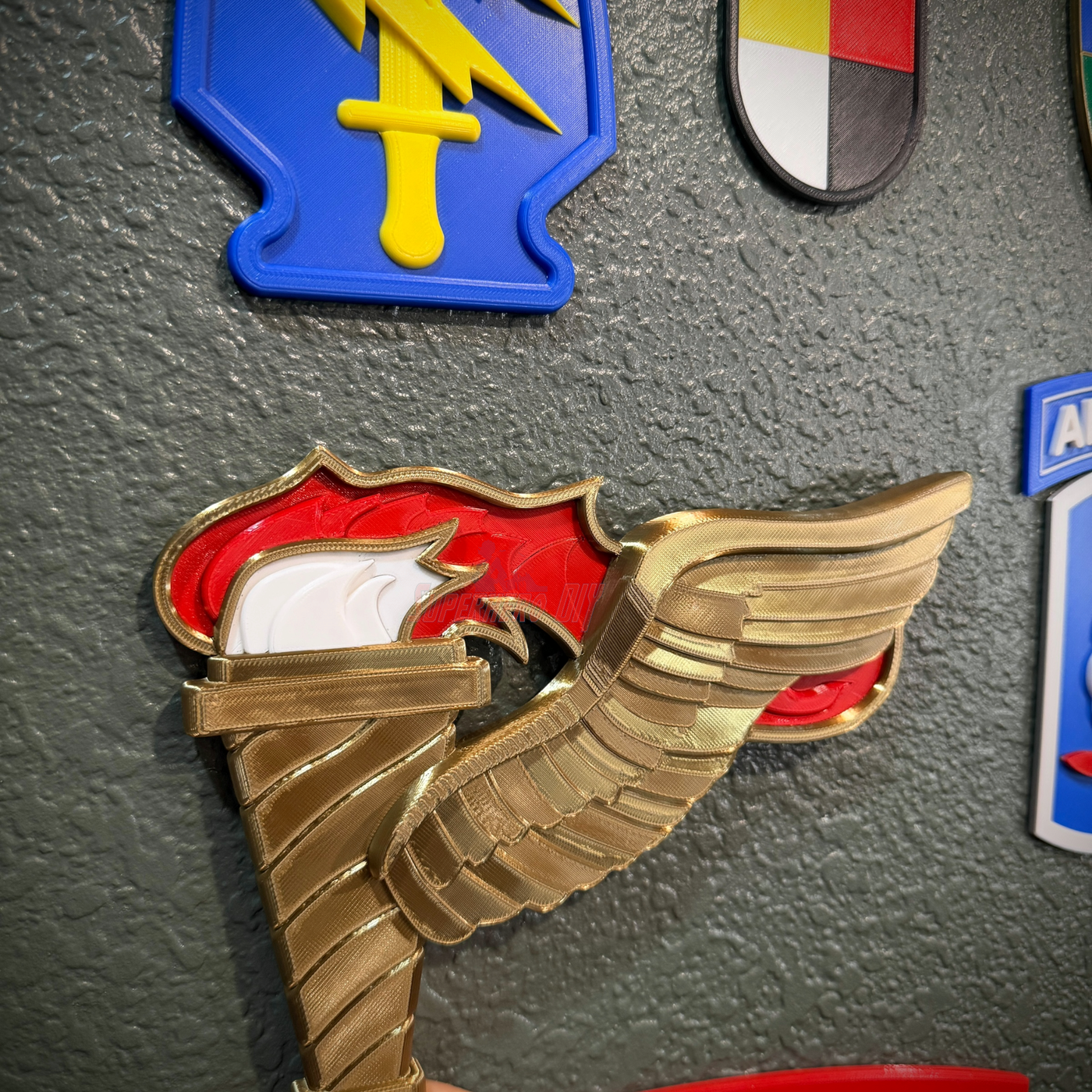 Close-up of Army Pathfinder Badge Display Insignia featuring winged torch design on a wall
