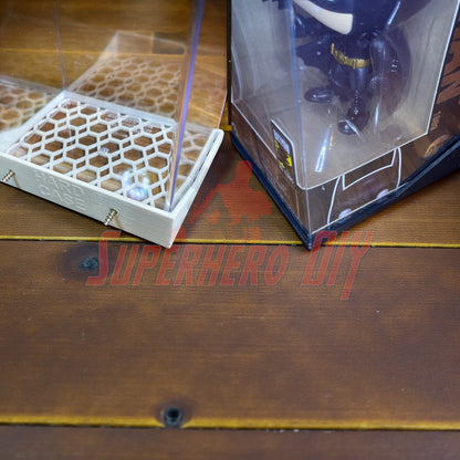 Hexagon Funko Pop display shelves with honeycomb base holding boxed Pop figure in protector case.