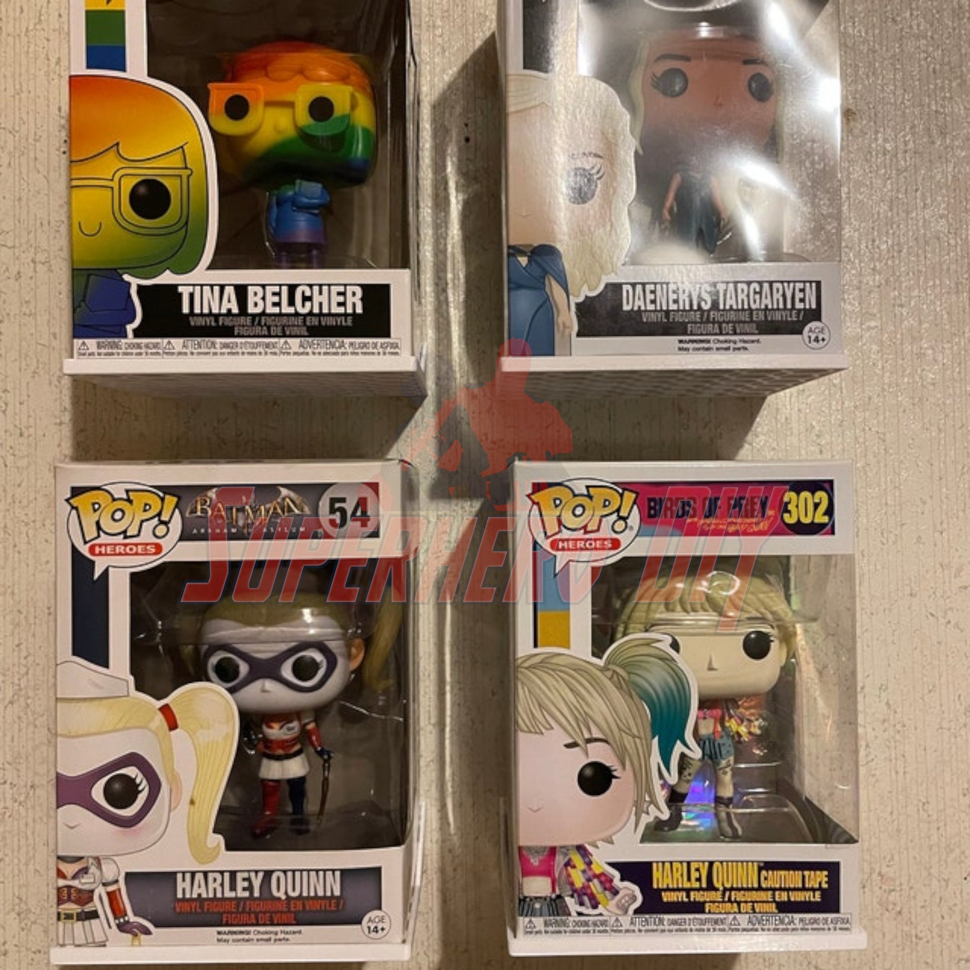 Four Funko Pop figures displayed on hexagon Funko Pop display shelves with soft or hard protectors.