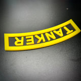 3D tanker tab in bright yellow, showcasing raised lettering and an arch design on a black background.