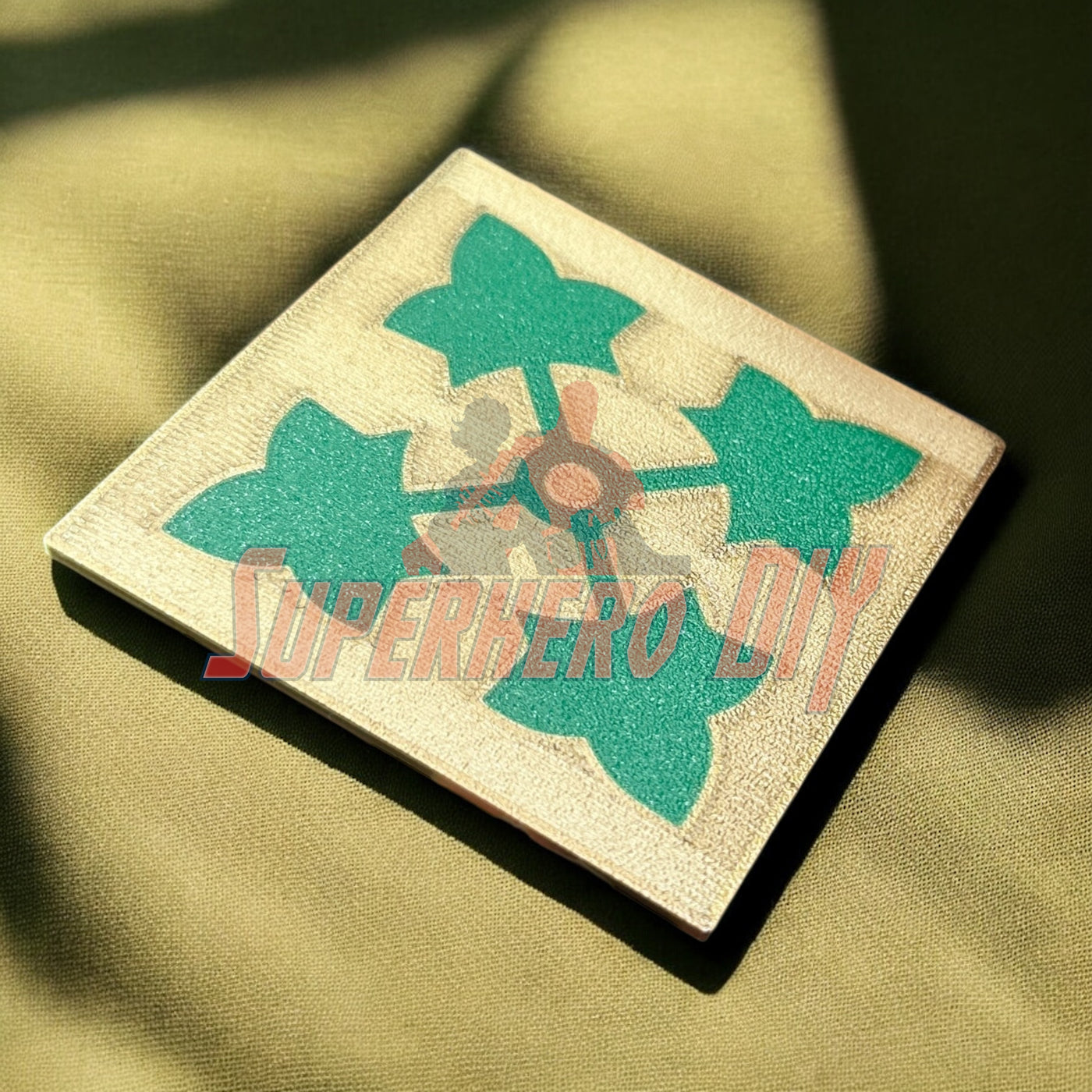 4th Infantry Division display insignia on fabric background, 3D-printed ivy leaf patch, military memorabilia
