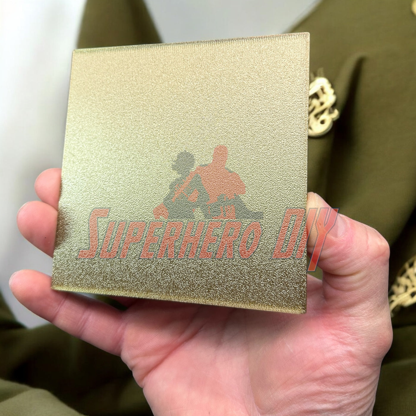 4th Infantry Division display insignia held in hand, showcasing gold 3D-printed detail against uniform background, made by veteran.