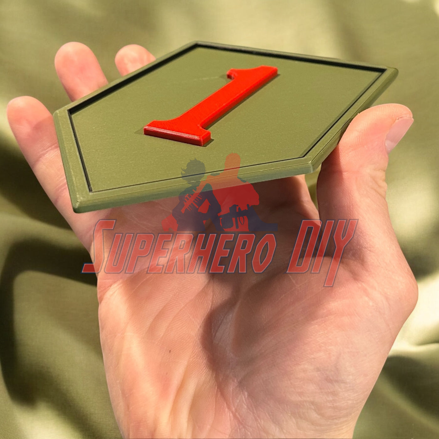 Hand holding 3D-printed 1st Infantry Division display insignia, Big Red One patch for wall display or shadowbox