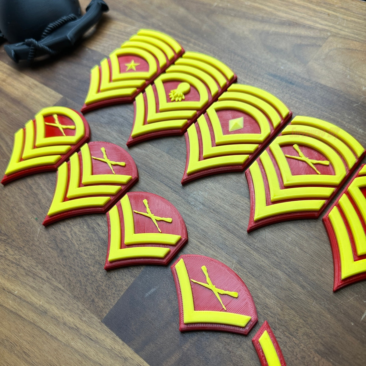 USMC enlisted rank insignias showcasing detailed 3D-printed replicas in red and yellow.